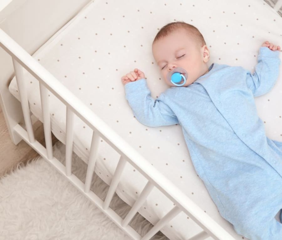Baby sleeping safely on their back in a crib