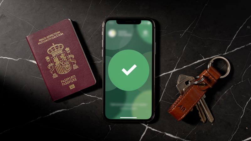 Smartphone mostrando pantalla de confirmación junto a un pasaporte, representando el proceso de invitación a clubes de cannabis en Madrid