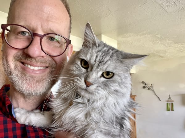 Away Home & Pet Care founder Robert Strickland holding Maine Coon during in-home cat sitting visit in Ogden Utah