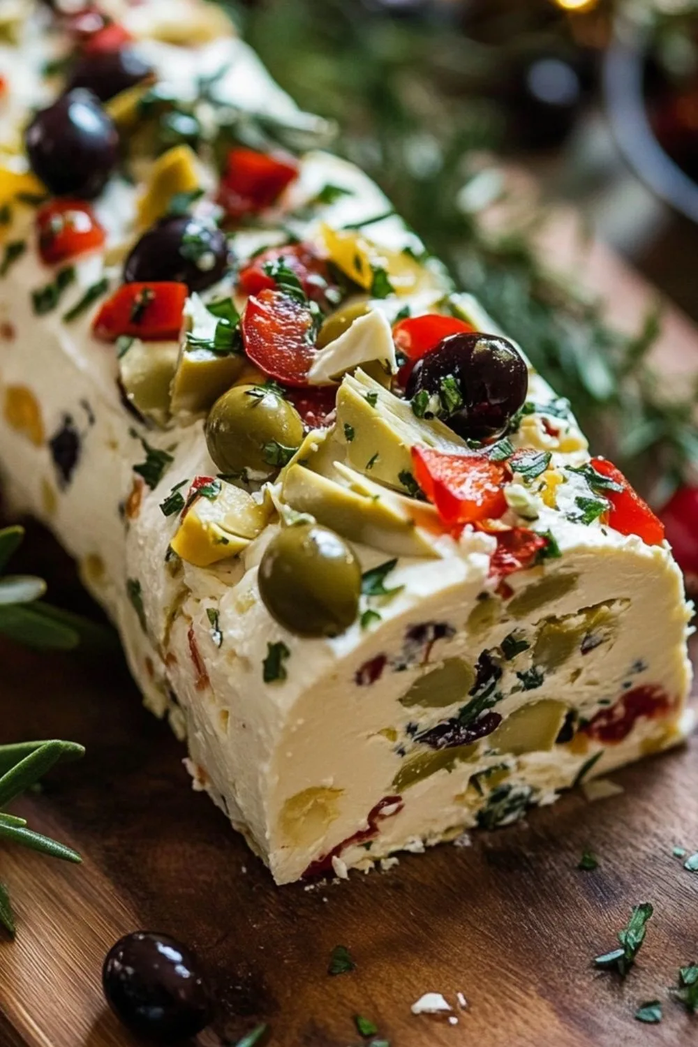 Festive Holiday Antipasto Cream Cheese Log assembled and garnished.