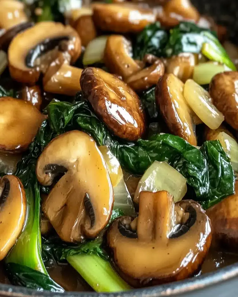 A vibrant Mushroom and Bok Choy stir-fry in a glossy sauce, topped with sesame seeds and scallions, served next to fluffy rice.