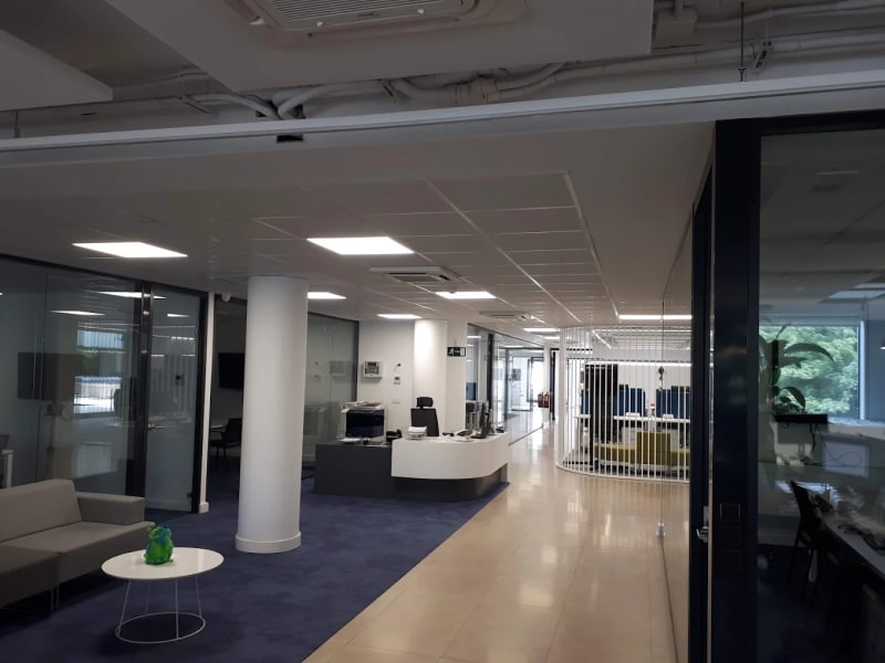 Recepción y zona de espera con mobiliario moderno en un coworking de Teatinos, Málaga