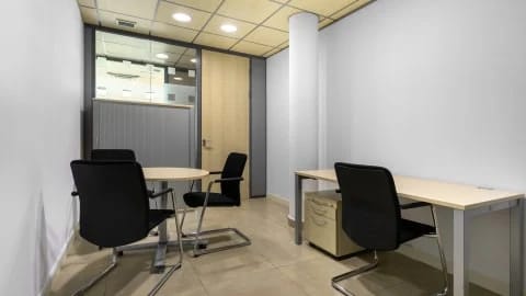 Oficina privada con mesa redonda y escritorio en un coworking de Teatinos, Málaga