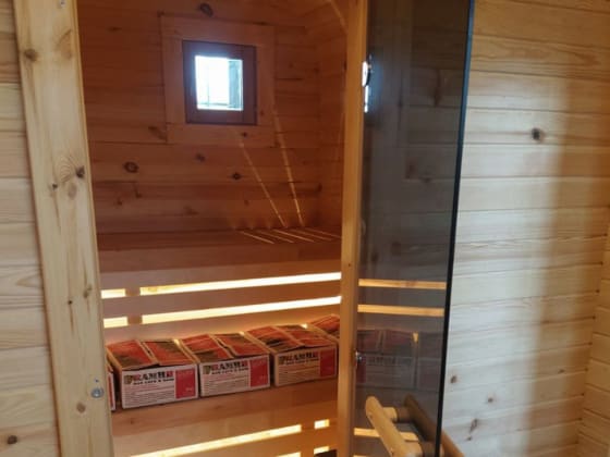 Wnętrze sauny ogrodowej — ławki, piec i oświetlenie