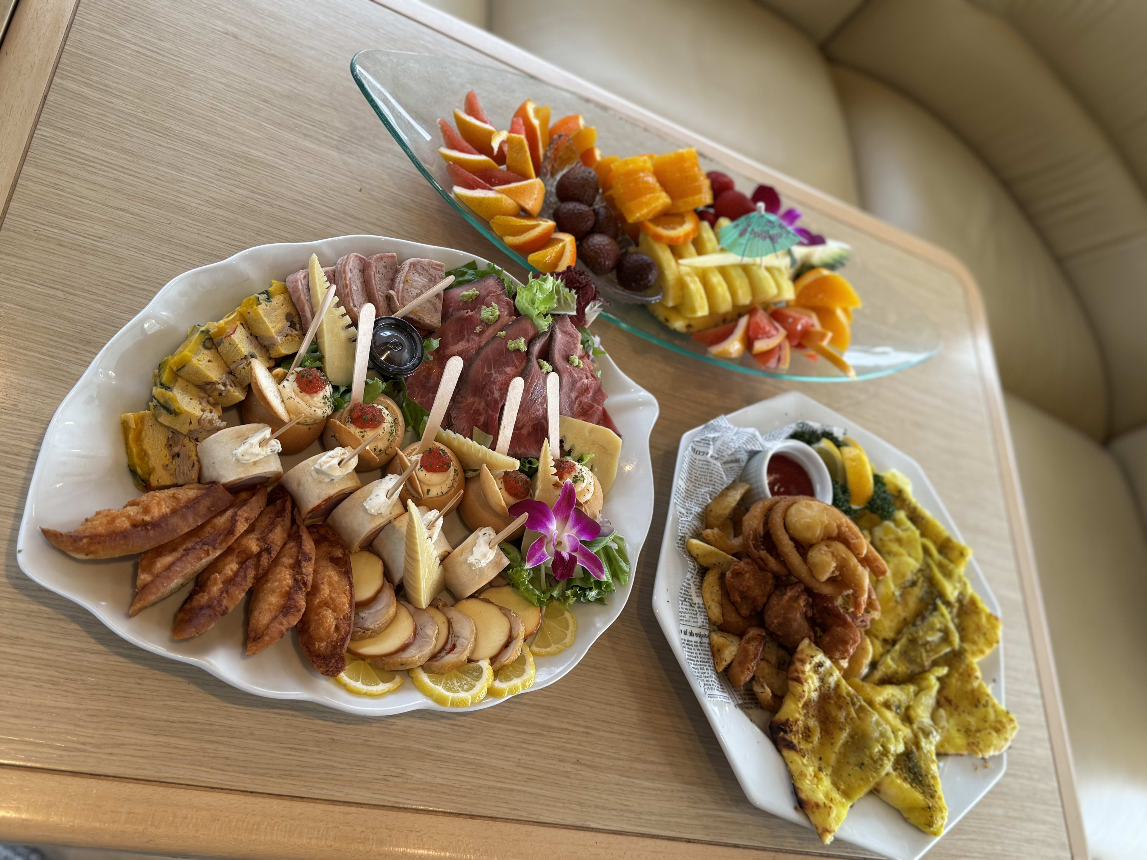 Appetizers, charcuterie board and fruit platter neatly presented on the yacht's dining table
