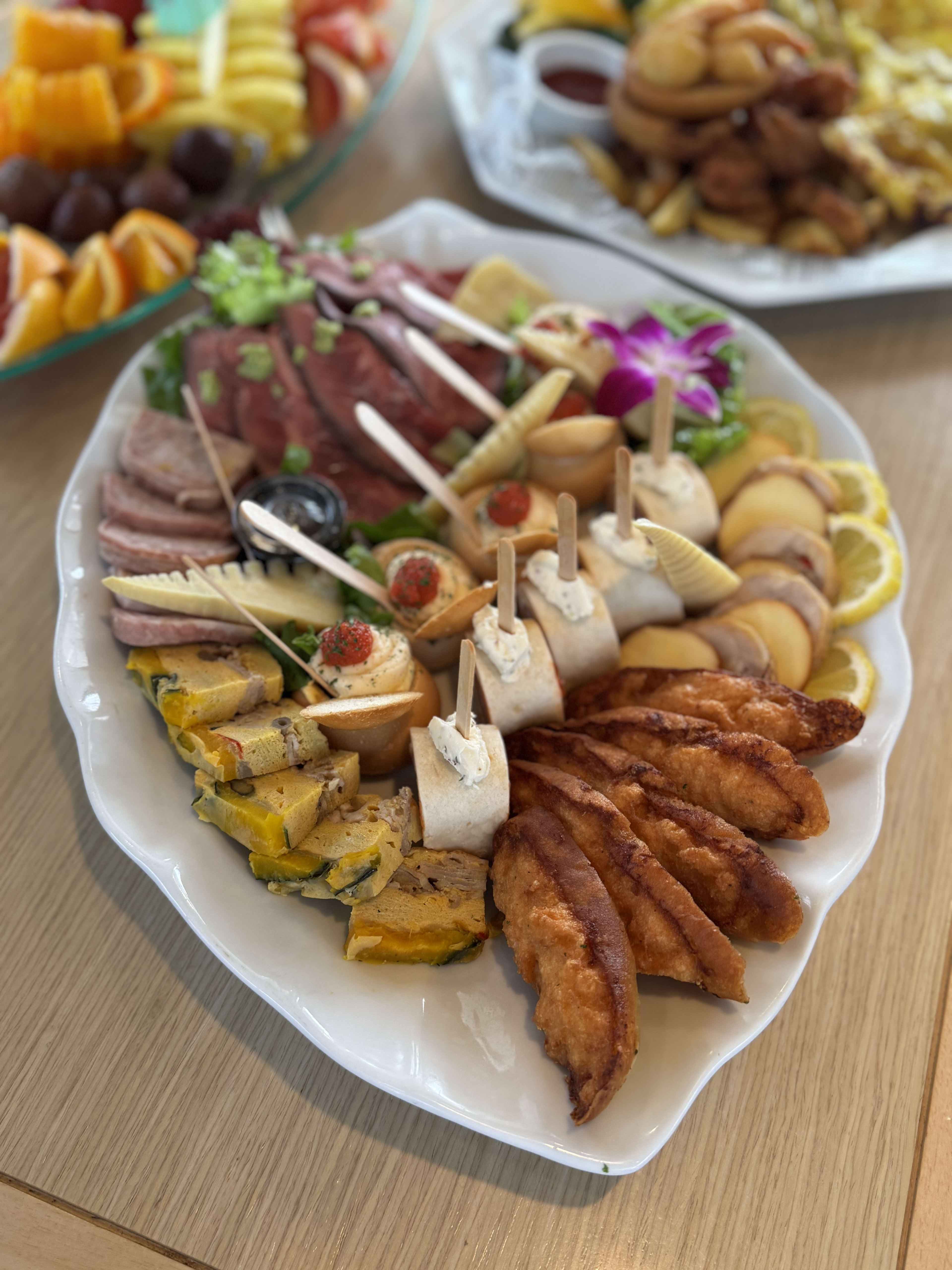 Charcuterie and appetizer platter with sliced meats, cheeses, nuts and hors d'oeuvres served on board