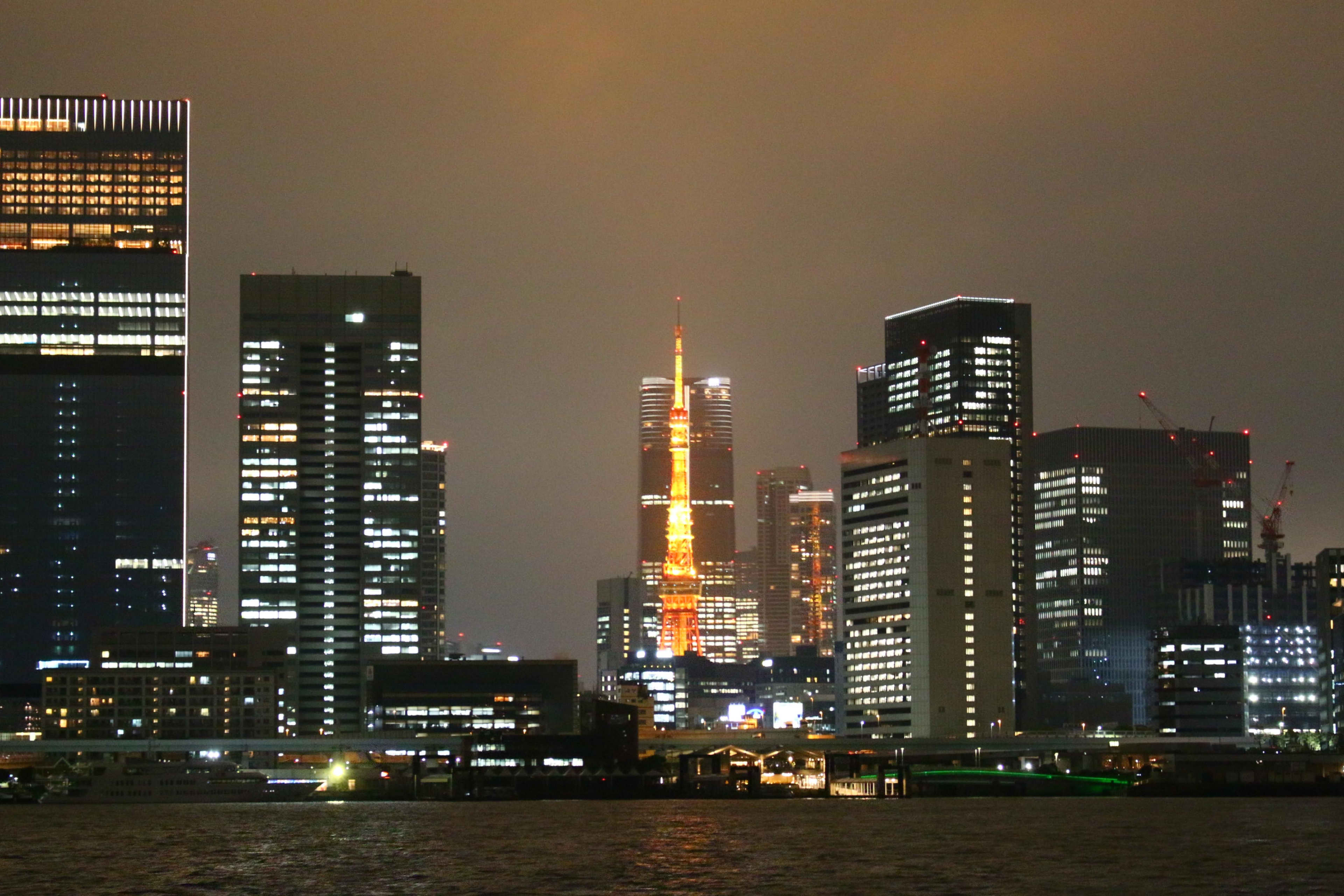 Tokyo Tower and the city skyline at night, seen from the water