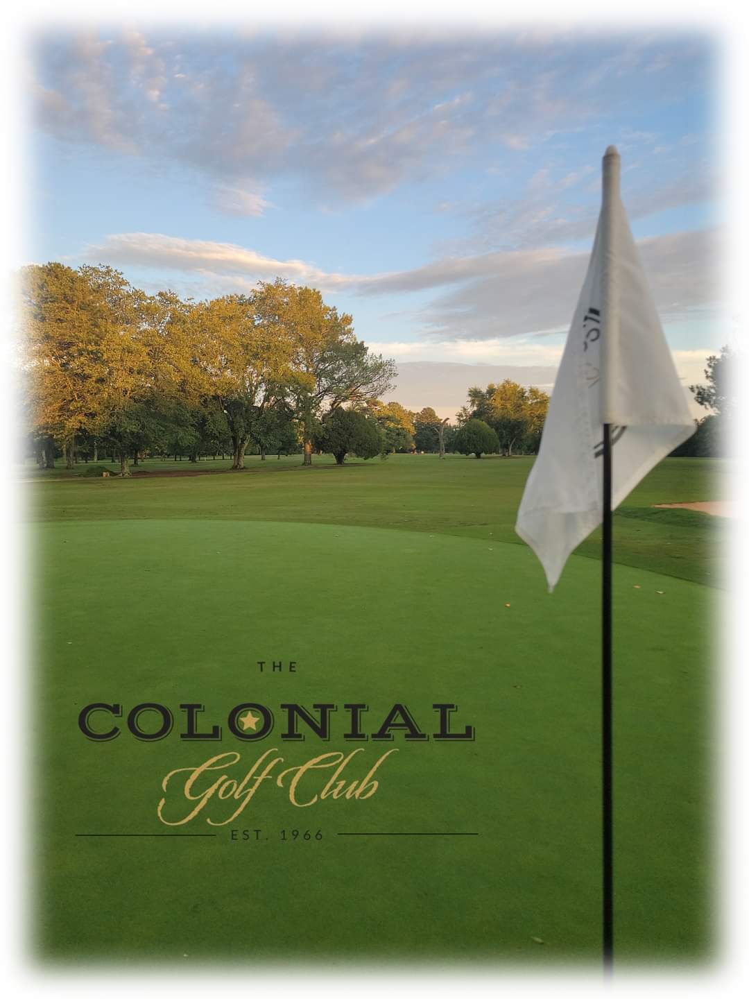 Colonial Golf Club branded image showing a pristine putting green with pin flag against autumn trees and cloudy sky backdrop.