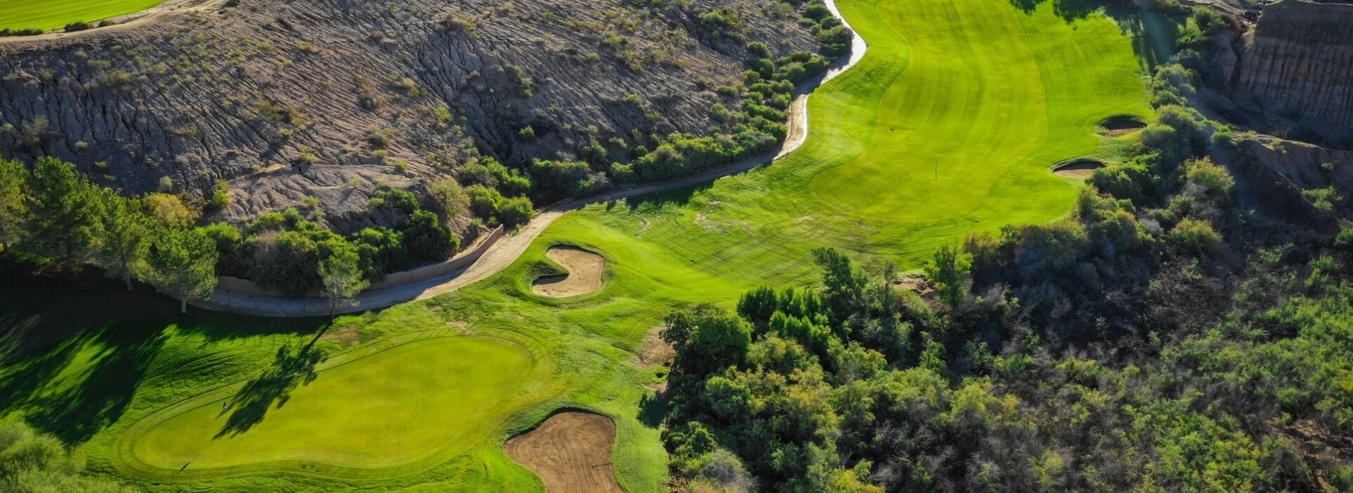 Aerial view of challenging golf holes at Quarry Pines carved through canyon terrain, showcasing the dramatic elevation changes and strategic sand bunkers.