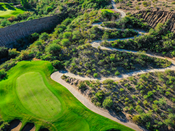 Overhead perspective of a golf hole at Quarry Pines showing the green complex surrounded by natural desert terrain and cart path access through rugged landscape.