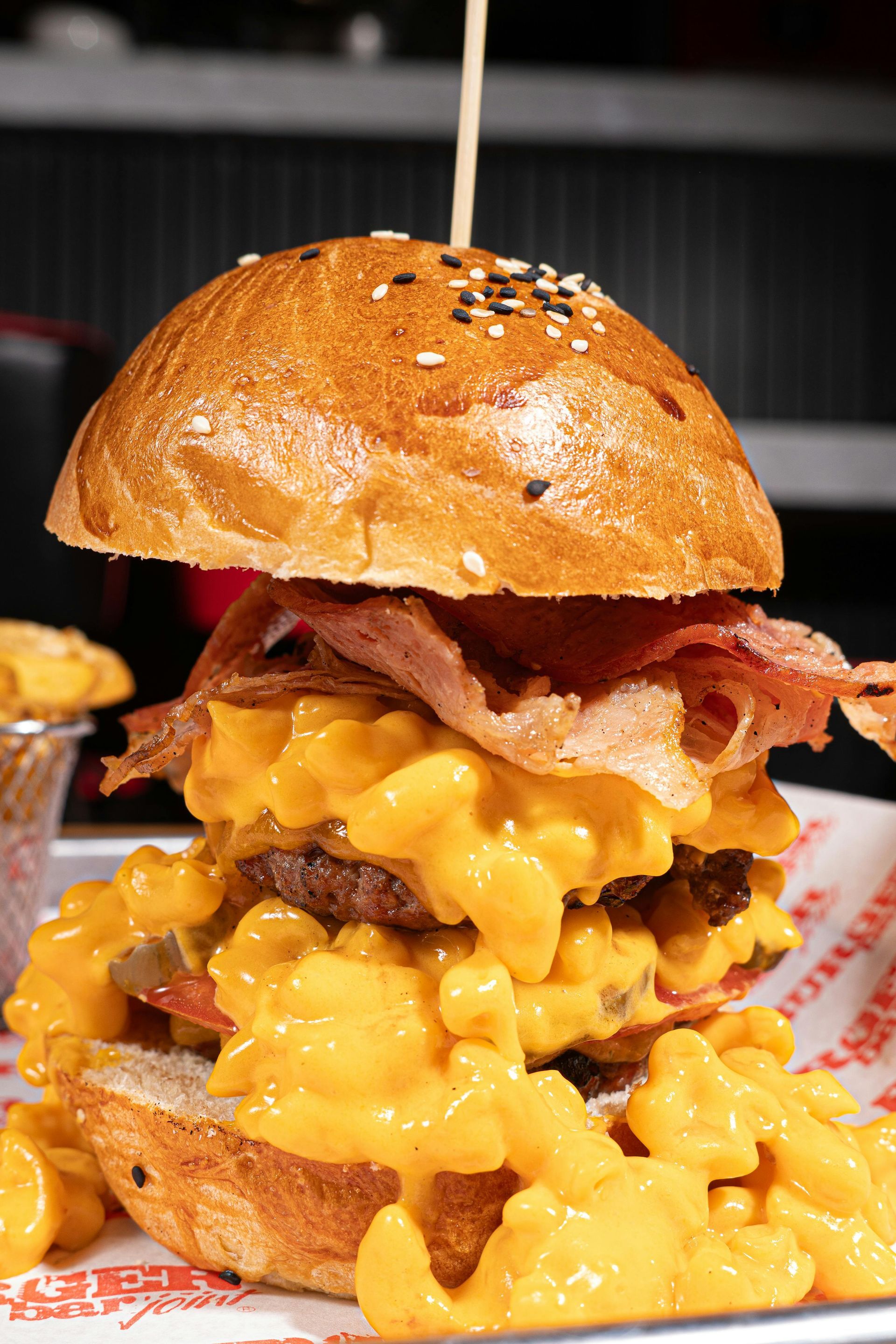 A towering gourmet burger with melted cheese, bacon, and loaded fries served at the 19th Hole Grille.