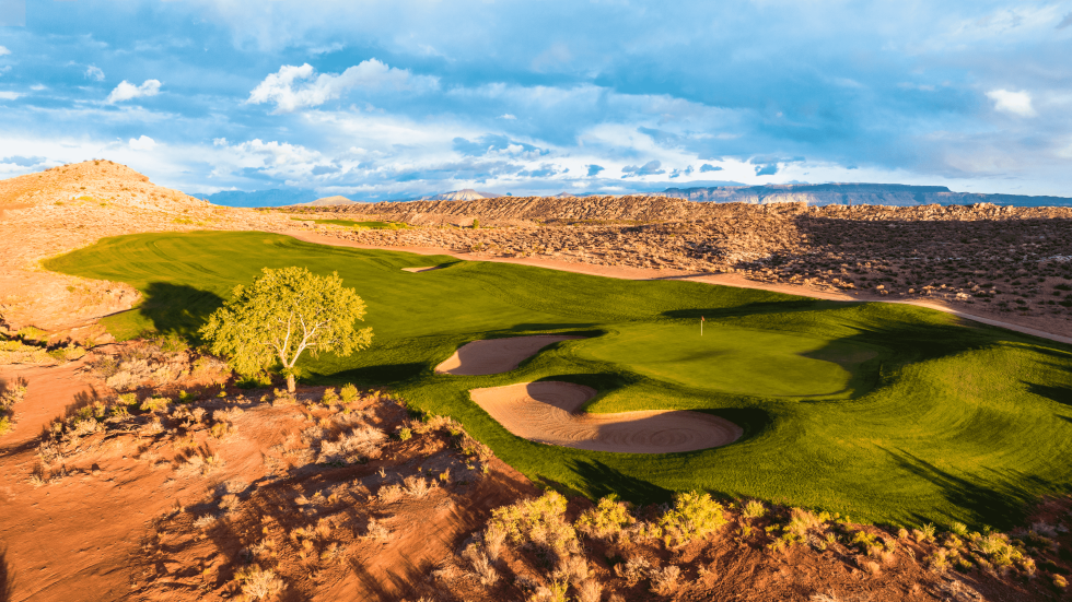 Aerial perspective of a desert golf hole featuring multiple sand bunkers strategically placed around an elevated green with a