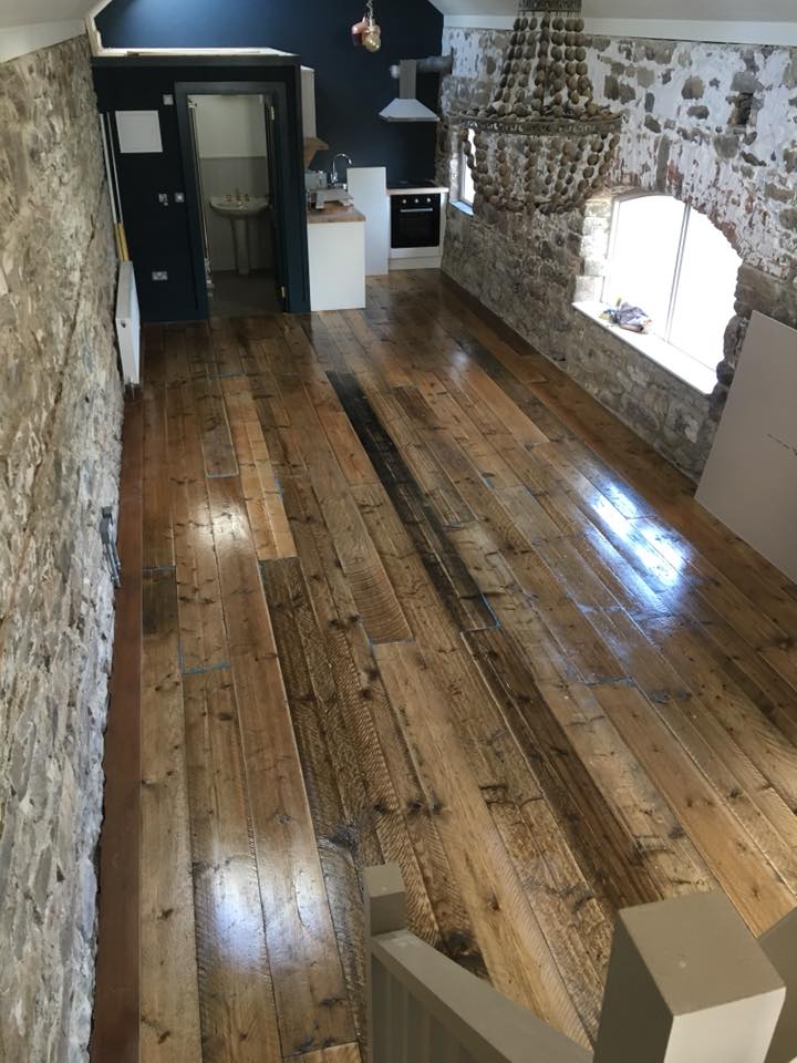 a farm house after being converted to a living quarters with a solid wood floor.