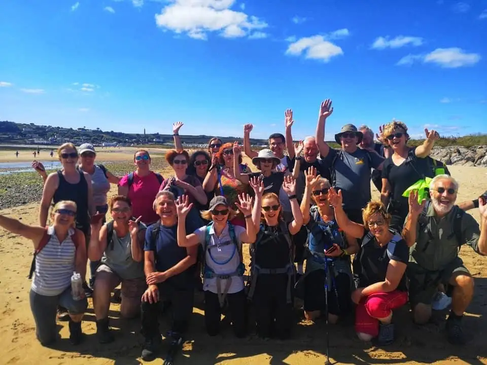 Sunny-summer-group-at-Ardmore-1 tour group posing for a photo at the end of Saint Declans Way at Ardmore beachg co. Waterford Ireland