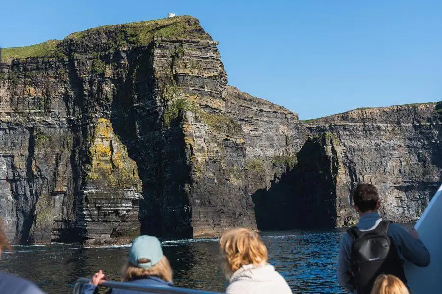 Tour group looking at the cliffs of moher from a boat in Ireland