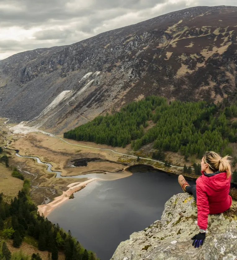 celtic-banner-large Woman traveler in a red jacket in the Spink Viewing Spot in Wicklow mountains national park, Ireland stock photo