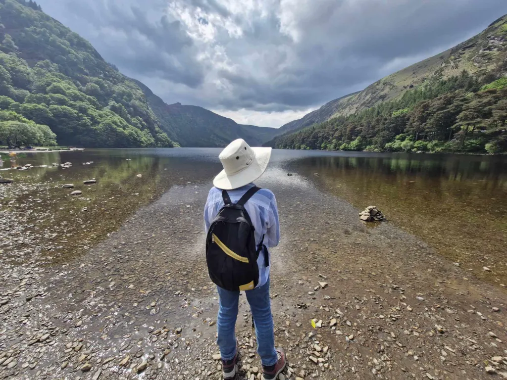 Walker on tour looking out over Glendalough lake Co. Wicklow Ireland