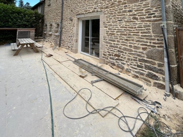 Façade ancienne en moellons de granit restaurée avec terrasse