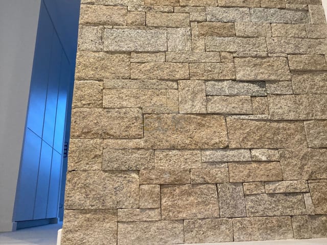 Mur intérieur en parement pierre clair sur double hauteur