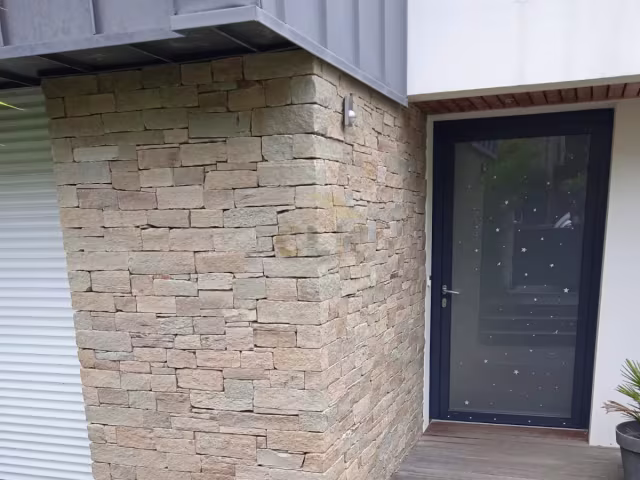Mur en parement de pierre sèche avec terrasse bois