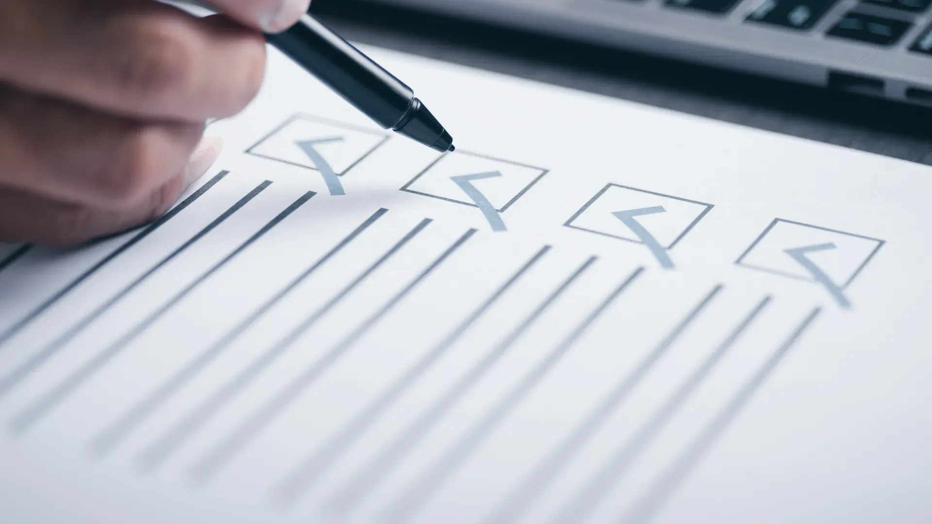 Mão de uma pessoa organizando uma checklist com papel e caneta