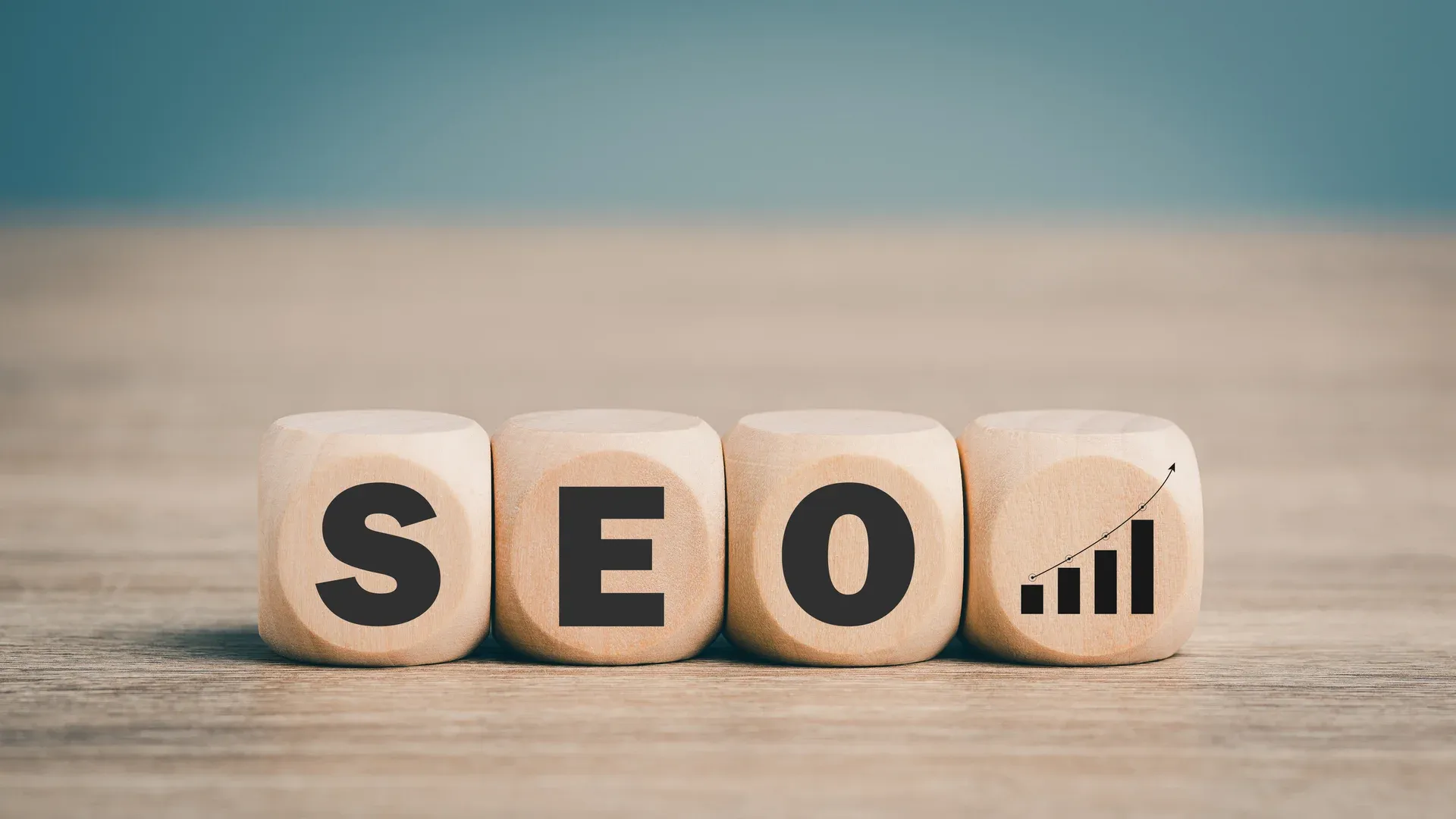 Cubos de madeira formando a palavra SEO com gráfico de crescimento ao lado
