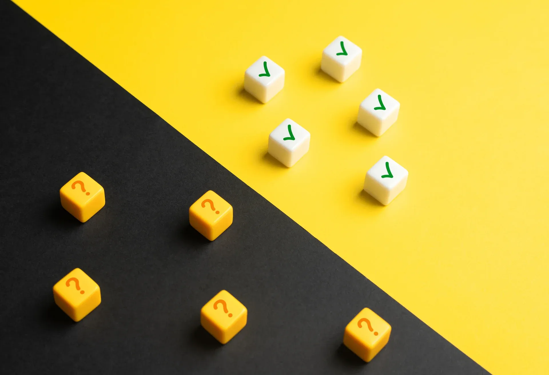 Cubos com check verde e interrogações divididos entre fundo amarelo e preto
