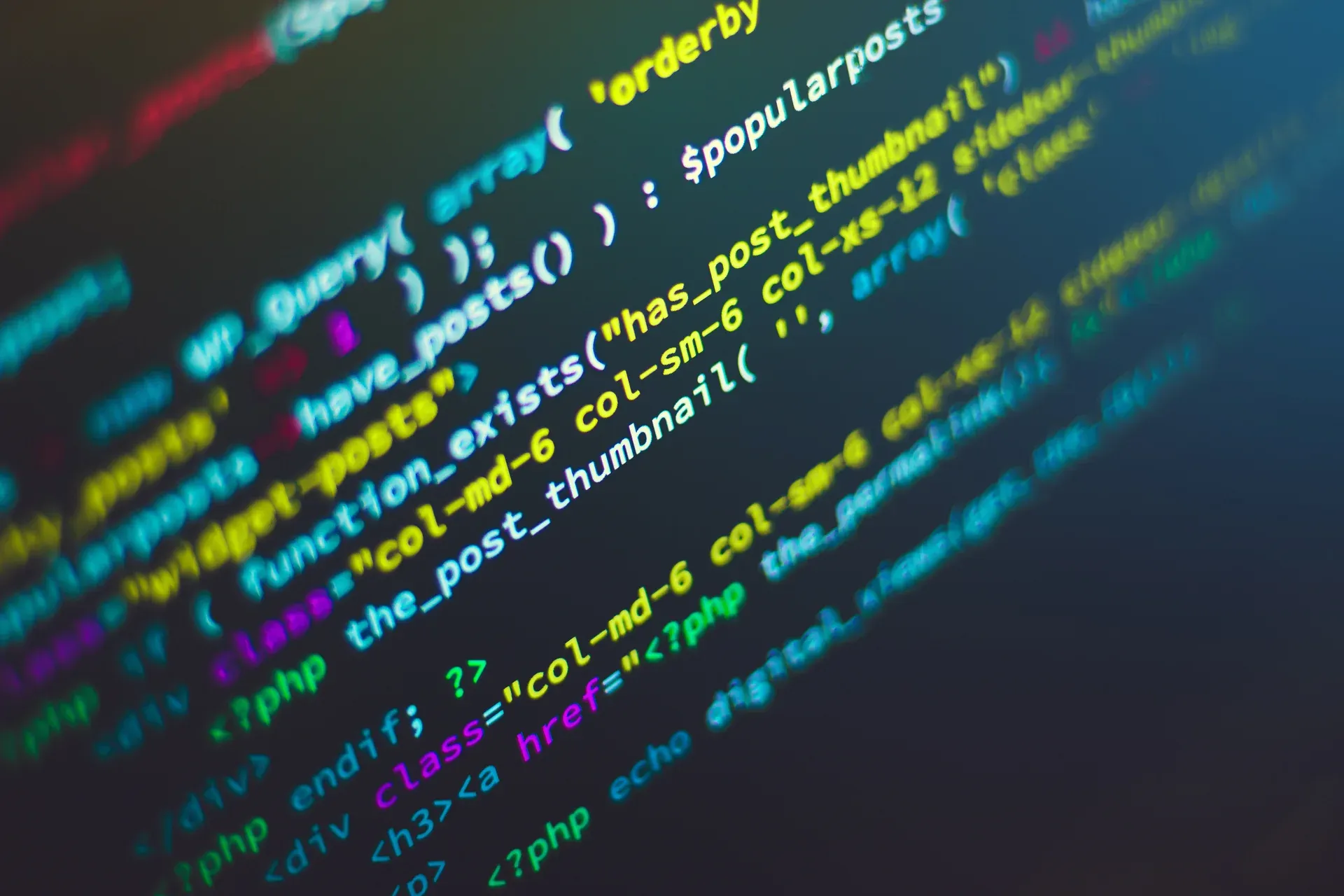 Close em tela de computador com linhas de código coloridas e foco seletivo