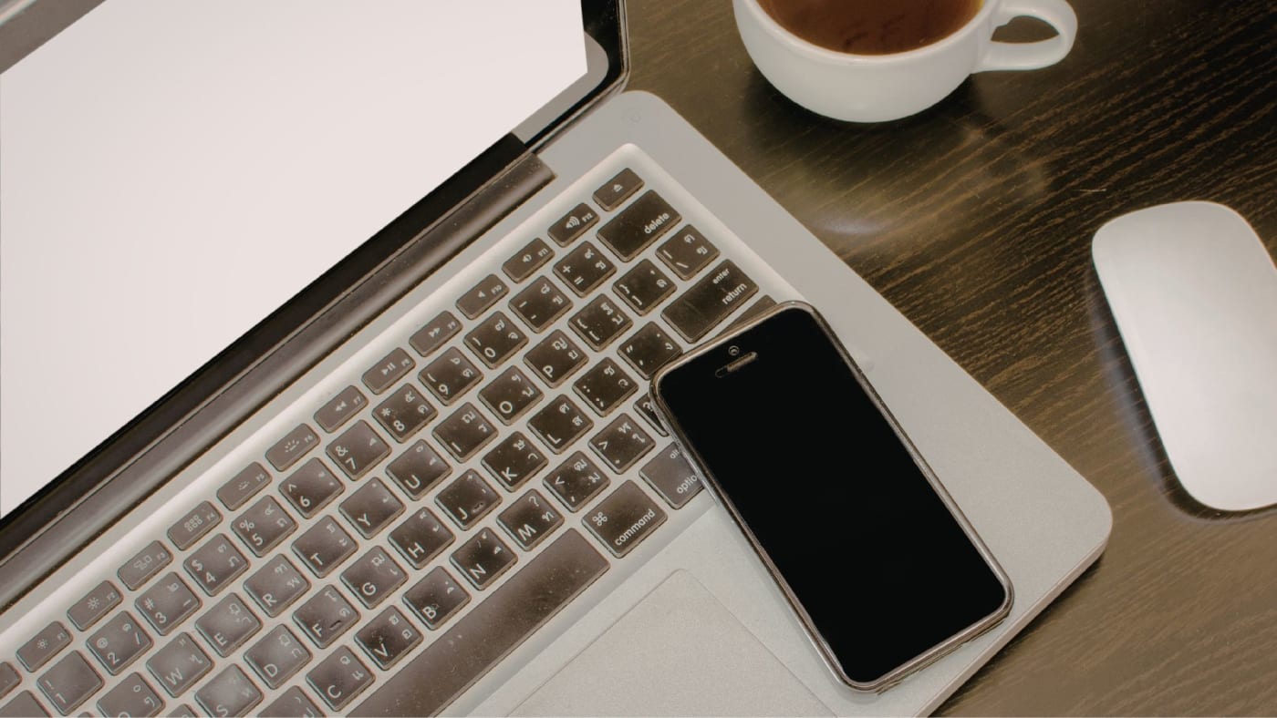 Laptop showing a business website next to a phone showing a Facebook page