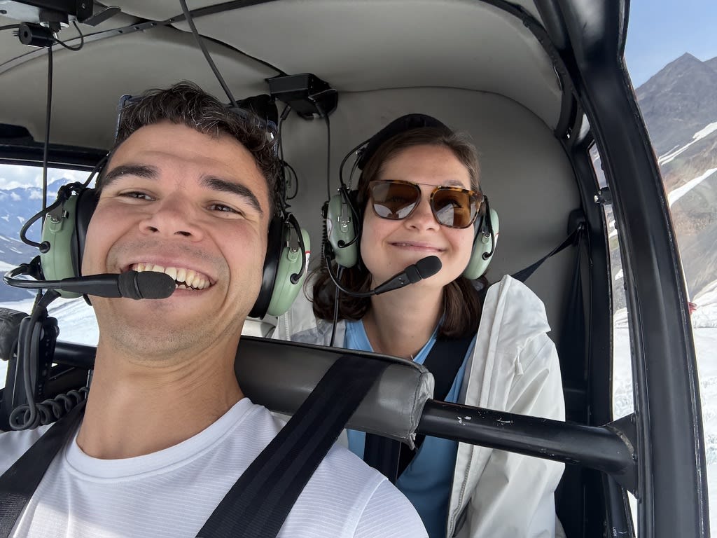 Kathryn and Alex wearing headsets inside the helicopter