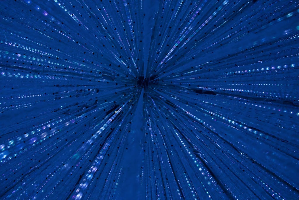 Alex standing among the lights in Infinite Crystals at TeamLab Borderless