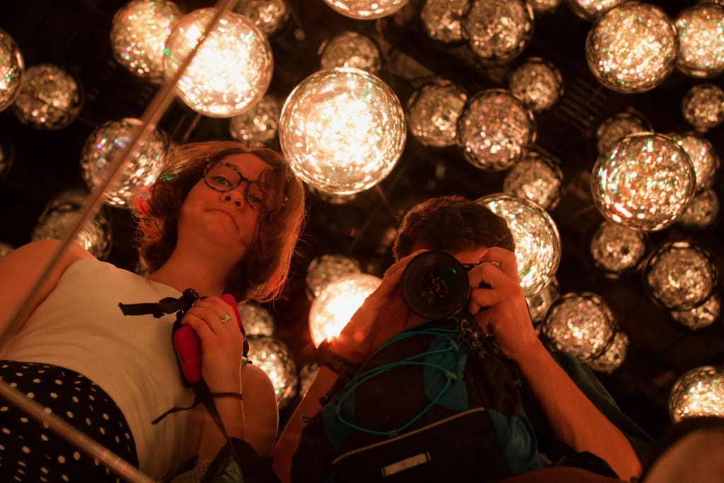 Visitors reflected among the spheres in Bubble Universe at TeamLab Borderless