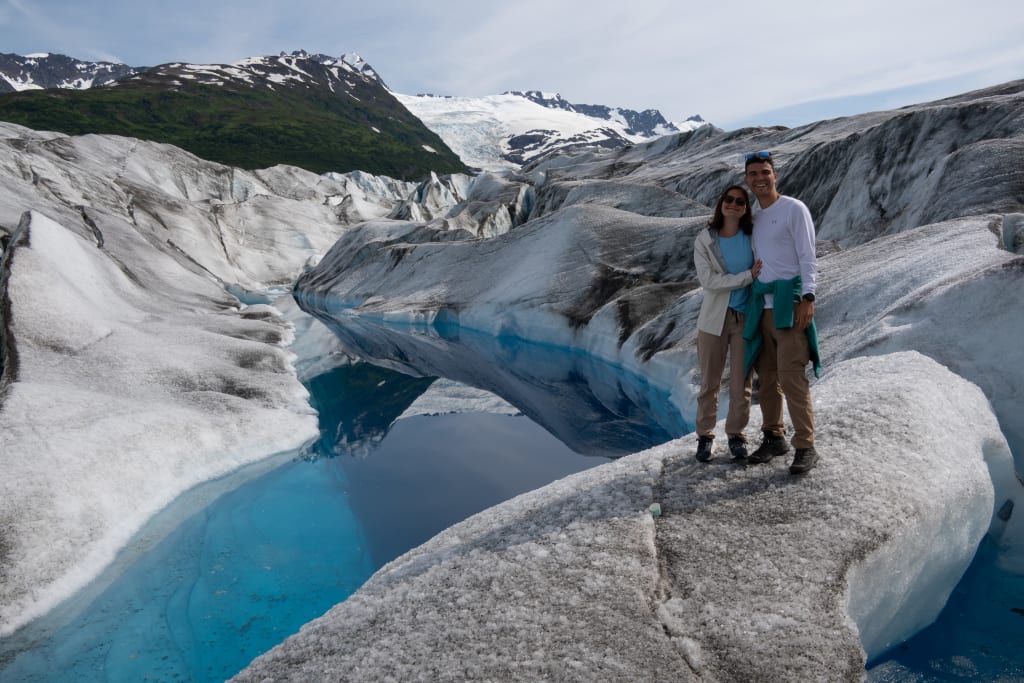Blue glacier pool with mountains in the distance