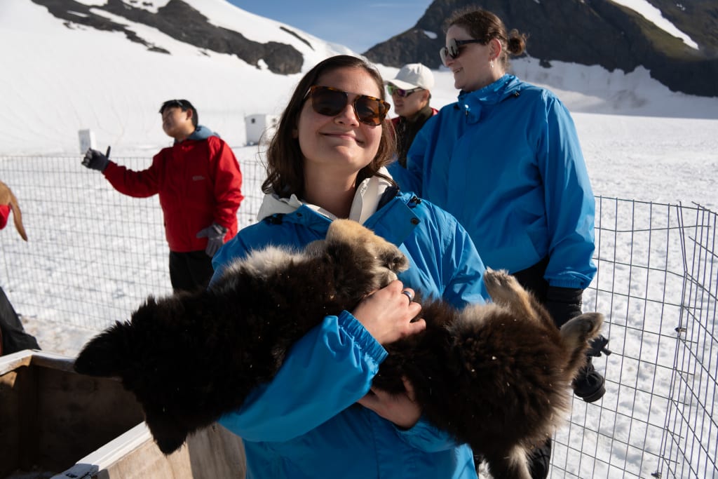 Kathryn holding an Alaskan husky puppy on Punchbowl Glacier