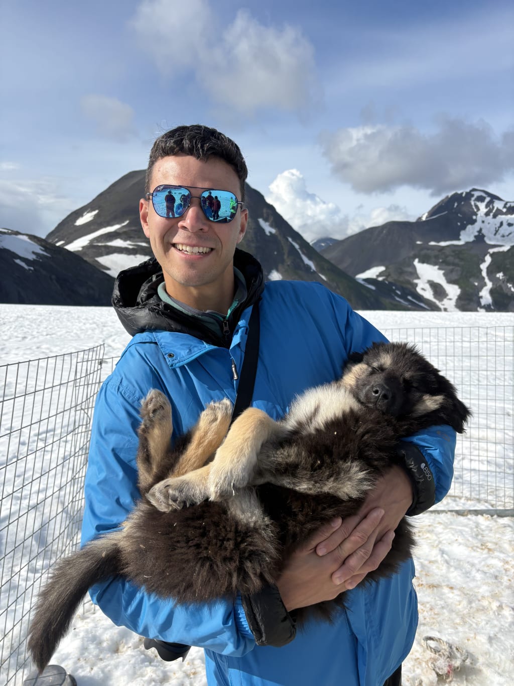 Alex holding a sleeping Alaskan husky puppy