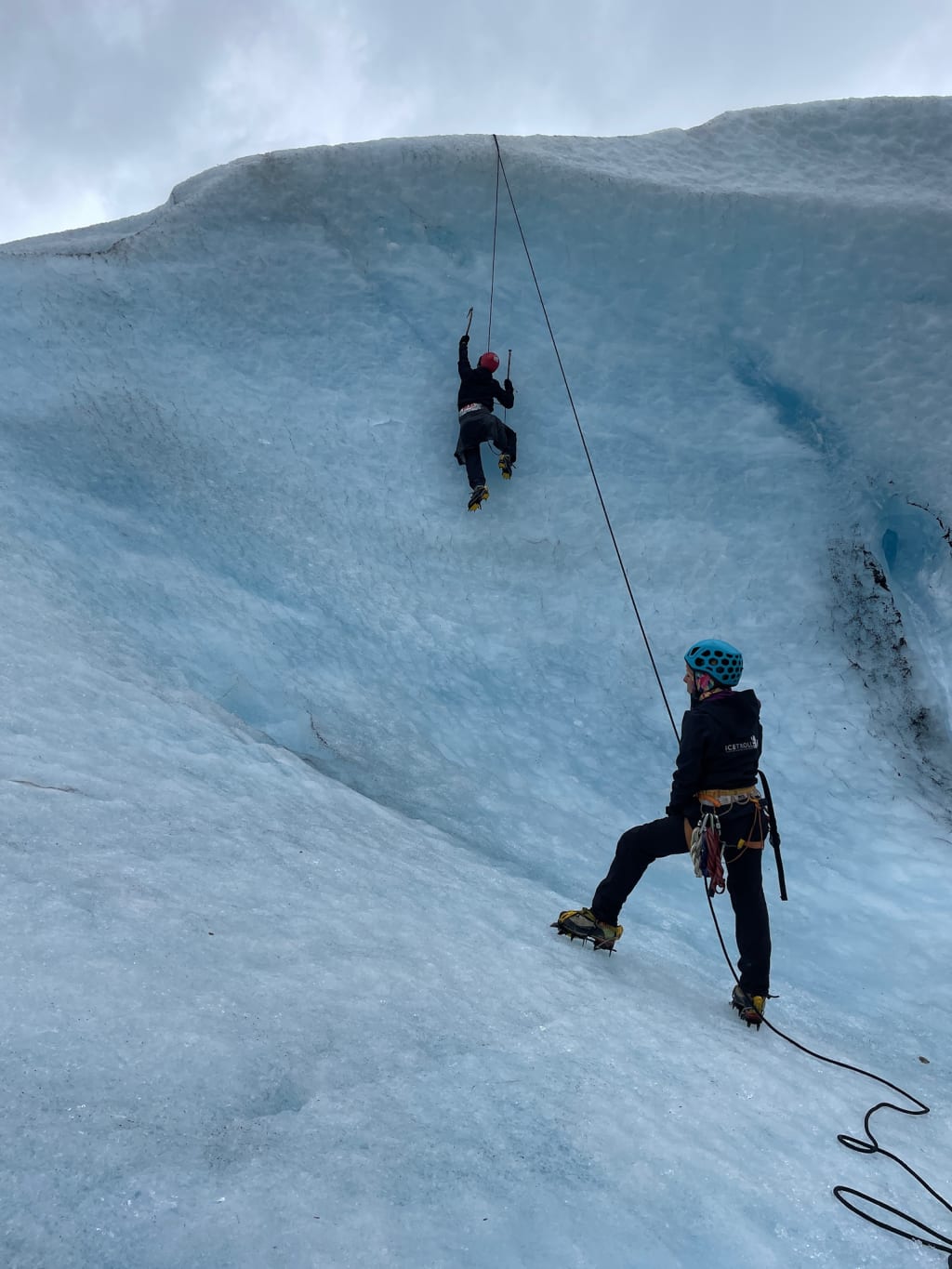 Ice climbing a harder glacier wall with an overhang