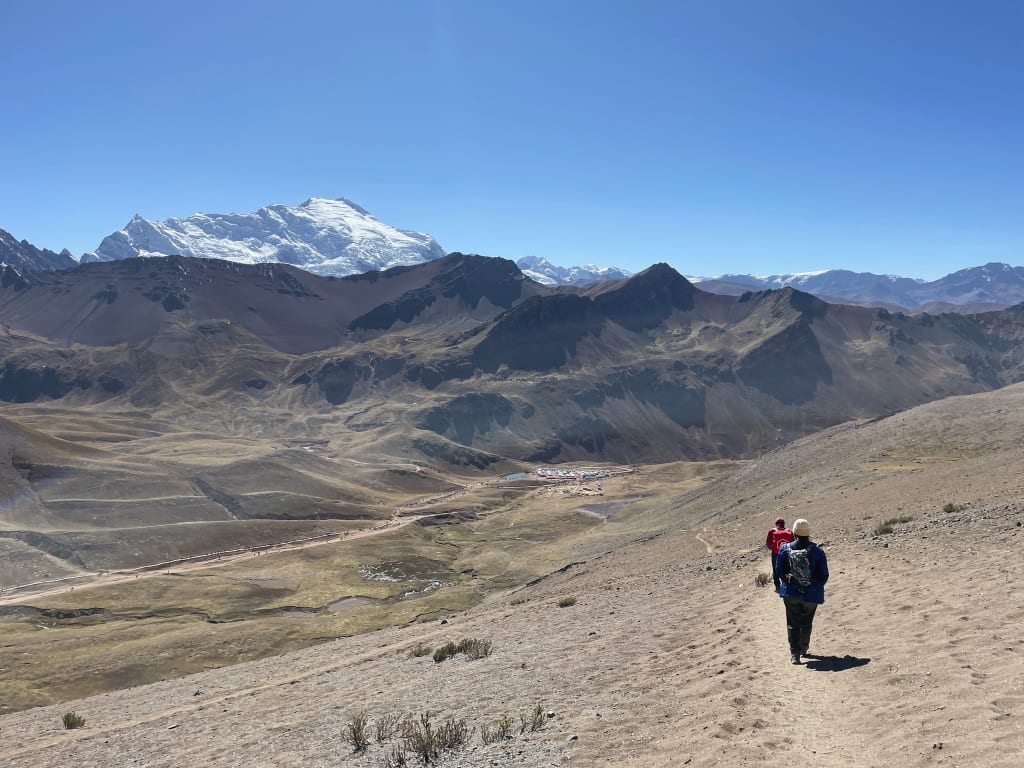 Parking lot below Rainbow Mountain filled with cars and tour buses