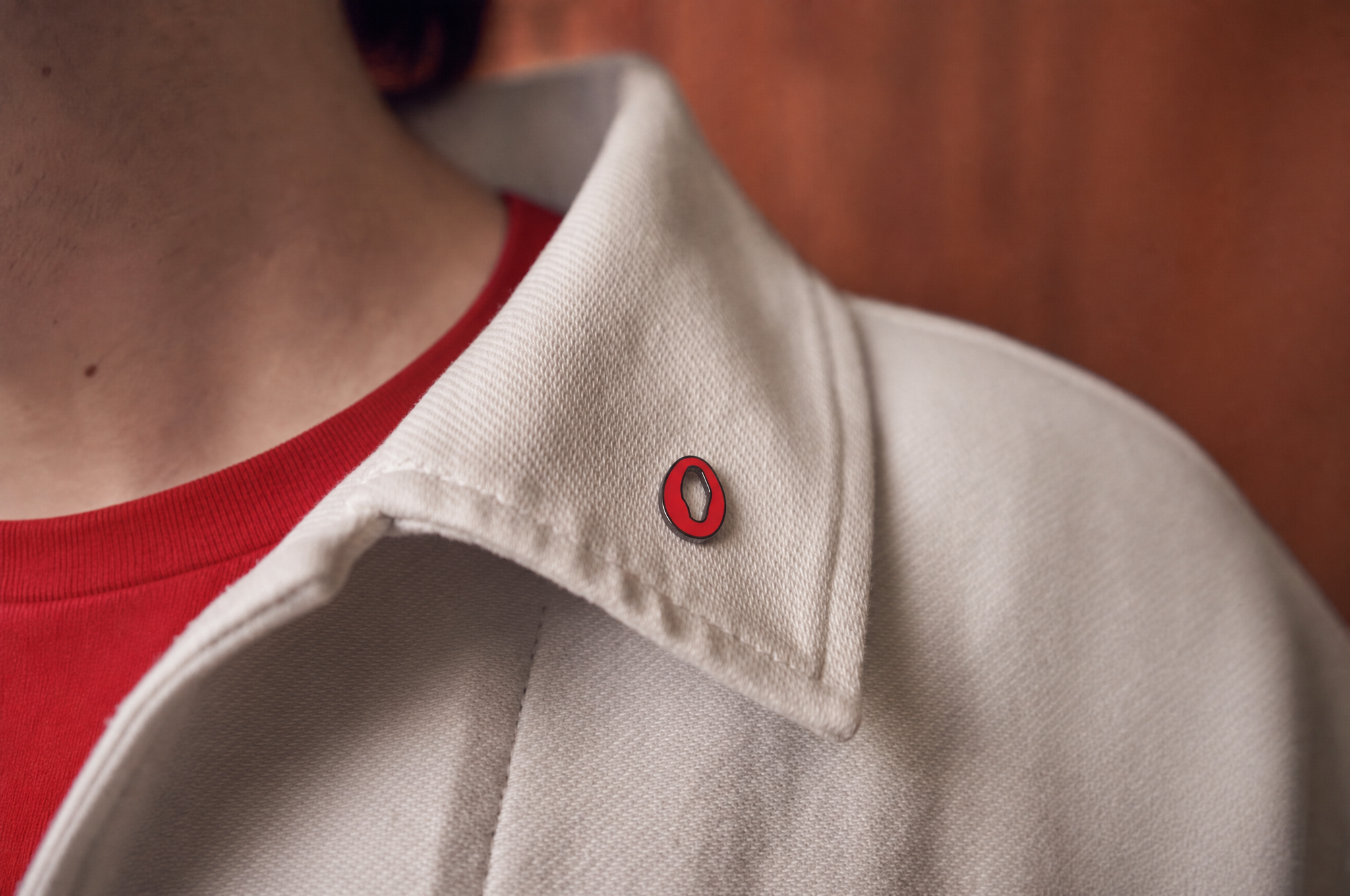 Olive enamel pin on coat