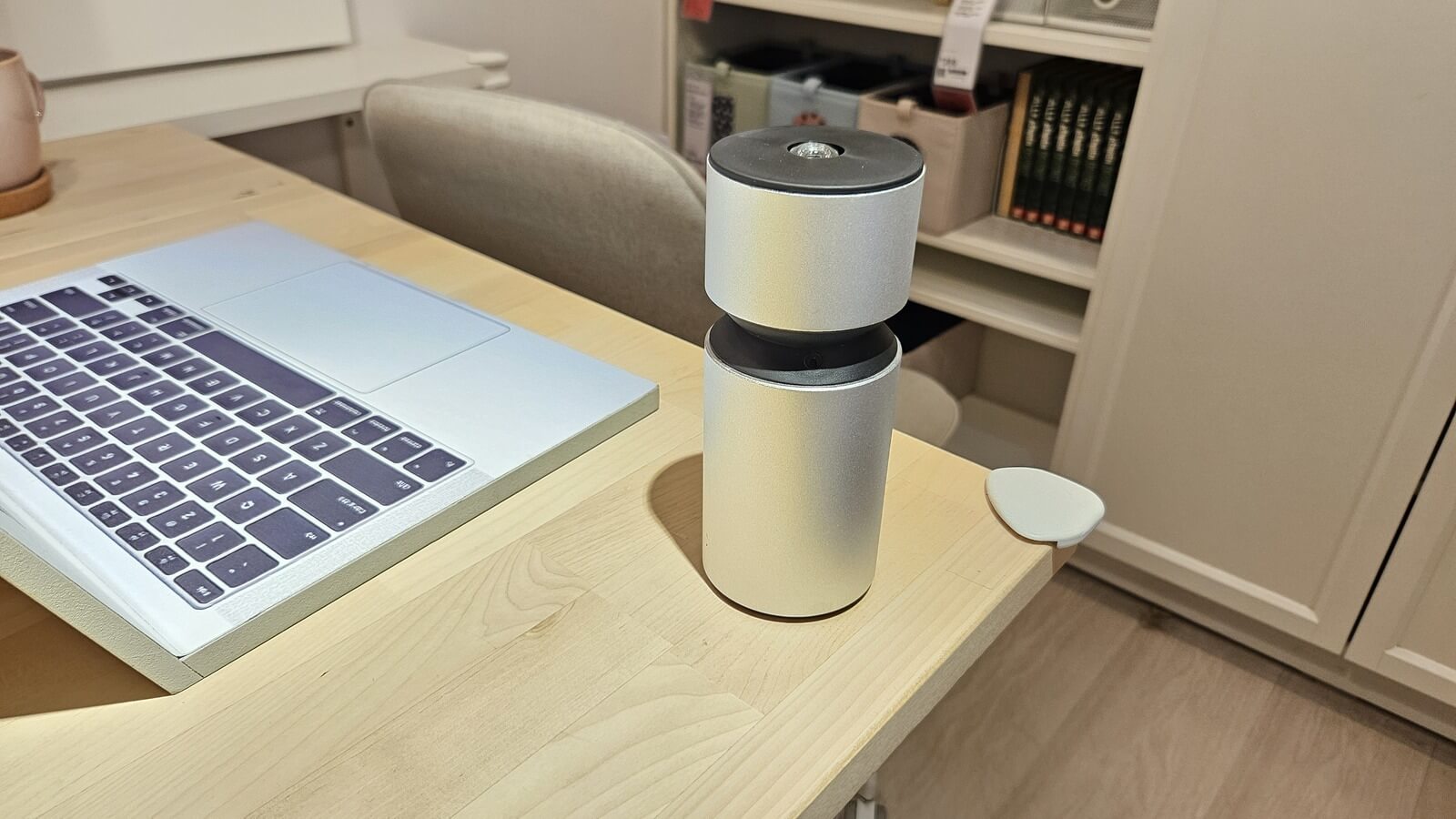 silver Nebulizing Diffuser on a desk beside a laptop