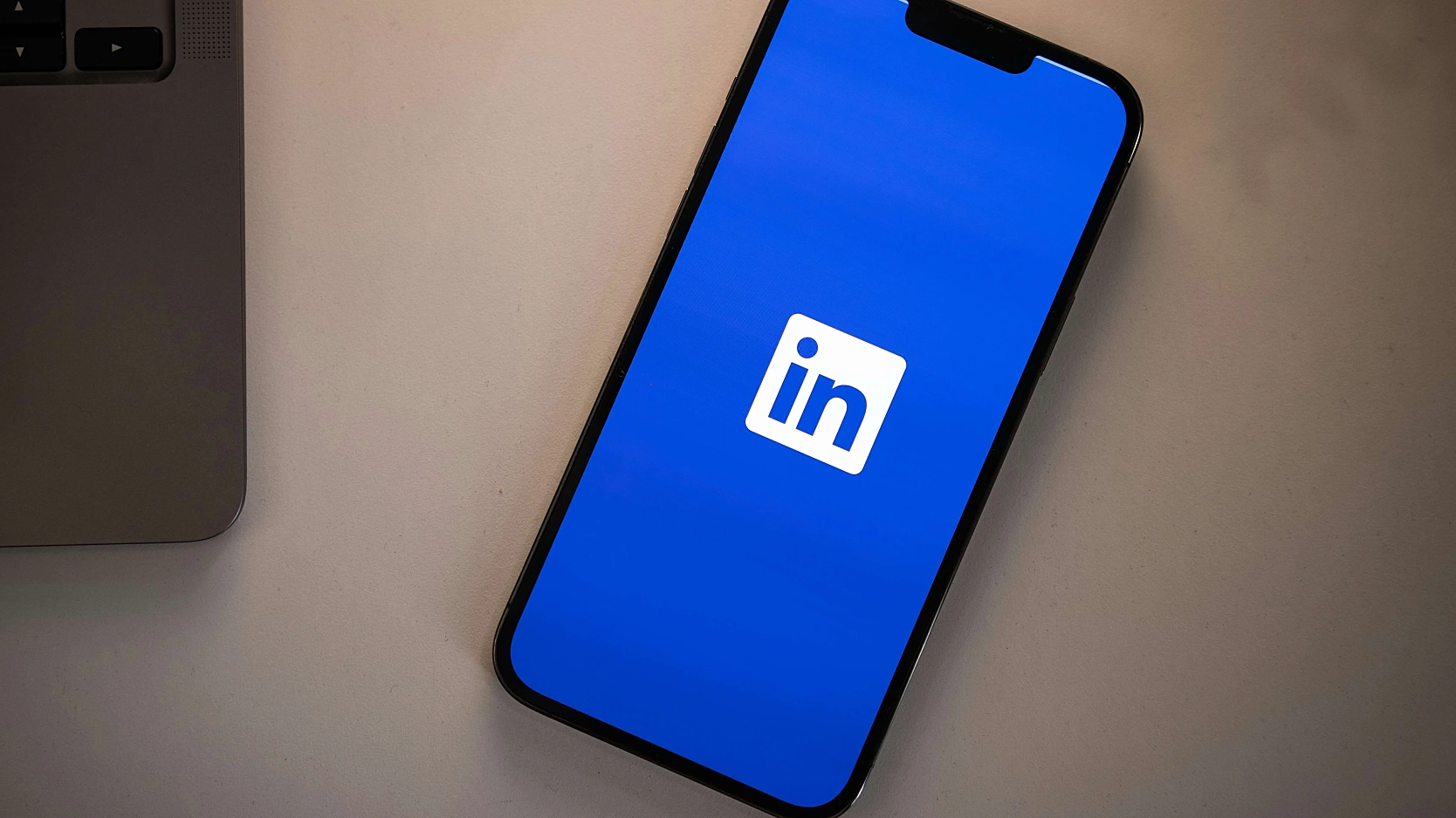 Nahaufnahmen eines Smartphones, dass gerade die App LinkedIn öffnet.