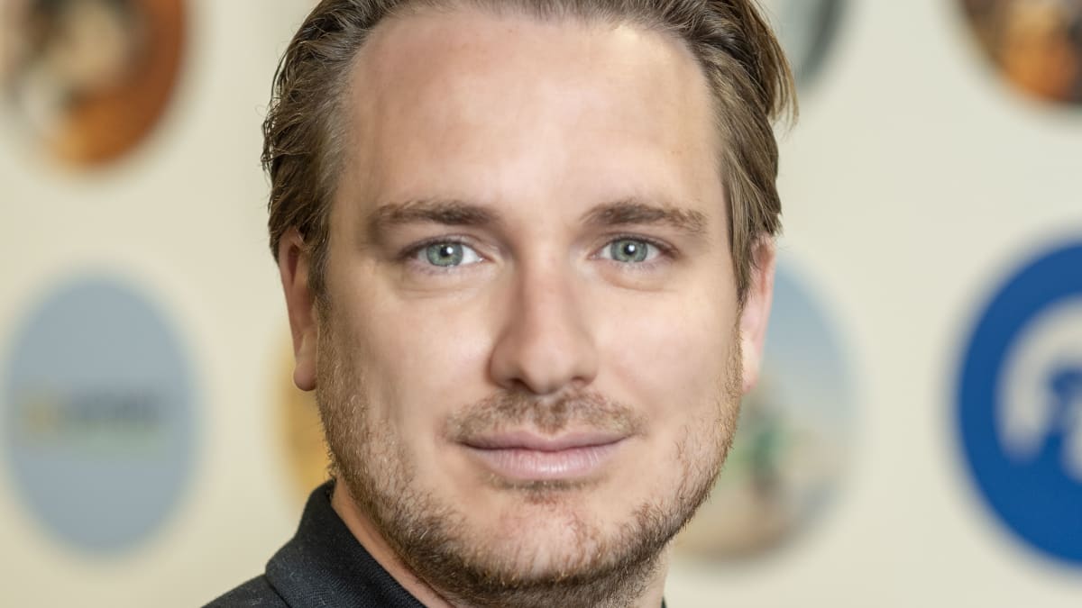 Christian Bennett, a man with light brown hair and blue eyes in a professional headshot