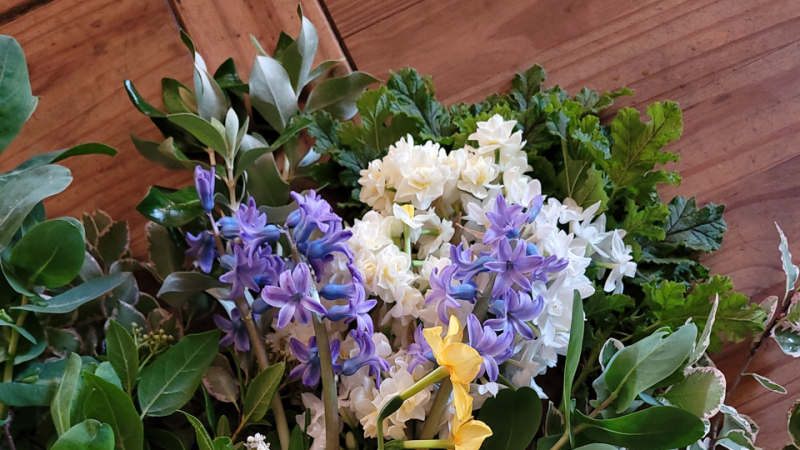 Spring flower arrangement with purple and white hyacinths, paperwhites, and yellow daffodil