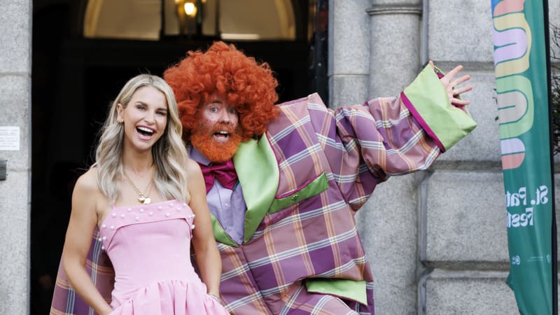 Vogue Williams smiling with costumed performer at St Patrick's Festival Grand Marshal event
