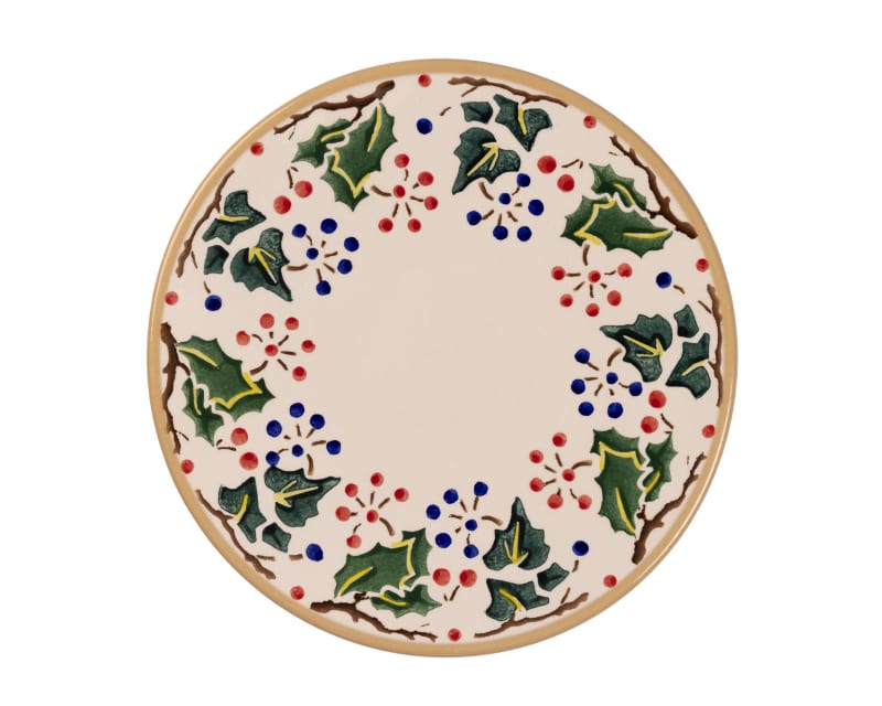 Ceramic plate with festive holly leaf and berry wreath design in green, red and blue on cream background