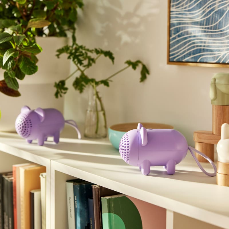Two purple elephant-shaped portable Bluetooth speakers with perforated grilles displayed on a bookshelf