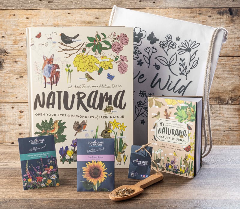 Naturama book and nature journal set with wildflower seed packets and canvas bag on wooden surface