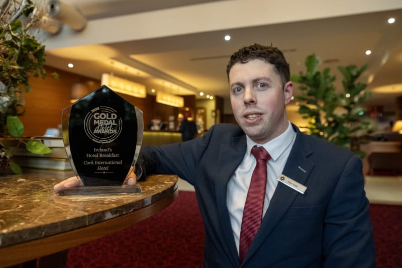Hotel staff member displaying Gold Medal Award trophy for Ireland's Hotel Breakfast at Cork International Hotel