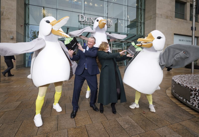 Man and woman playfully posing with three seagull mascots outside Dundrum shopping centre