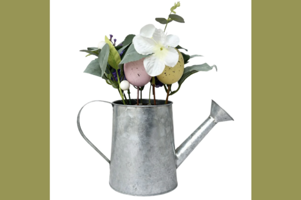 Galvanized watering can with artificial flowers and decorative Easter eggs arrangement