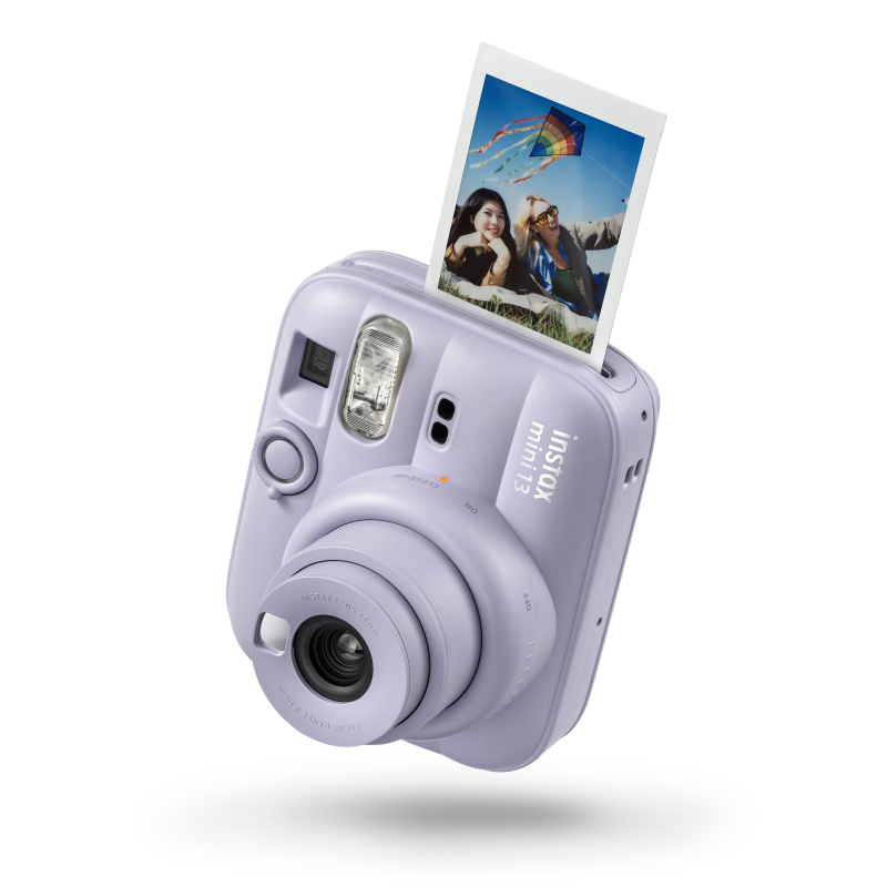 Purple instant camera with photo of two women and kite emerging from top